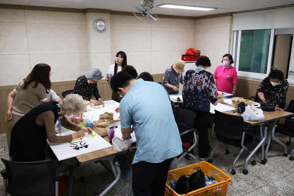 동아리 회원들이 멸종위기 동물을 병뚜껑으로 표현하고 있다​​​​​​​사진 김모니카